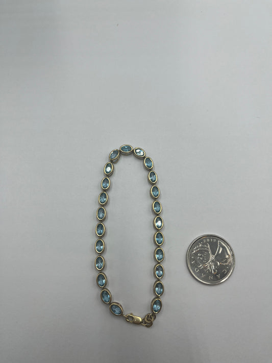 Oval blue topaz tennis 10 Karat gold bracelet.